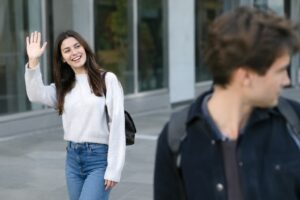 A person waving at someone who is looking away - colleague is ignoring me